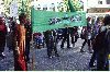 Två personer bär en grön banderoll med texten Grön Ungdom STHLM. (Klicka på bilden för att se en större bild)