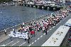 Flygbild på demonstrationståget med banderollen i täten. Man ser även en bit av Strömmen och Norrbro i bakgrunden (Klicka på bilden för att se en större bild)