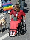 En rullstols buren person med regnbgsflaggan (Klicka p bilden fr att se en strre bild)