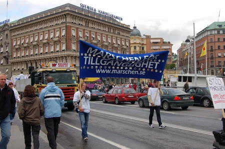 Bild från Marschen för tillgänglighet 2006; täten på marschtåget med banderollen och banderollbärarna. Foto: Miles Goldstick